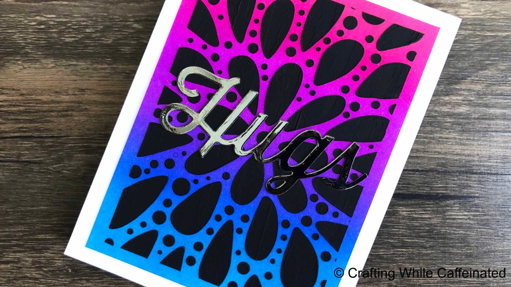 A handmade greeting card with a bright ink blended background and black modeling paste stenciling with the new explosion stencil from tcw.